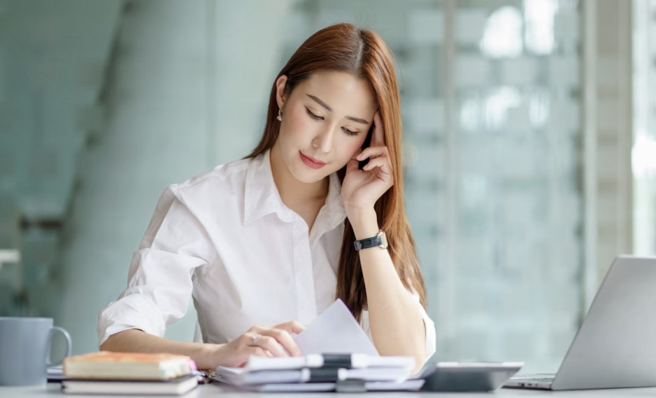A person reviewing paperwork at a desk