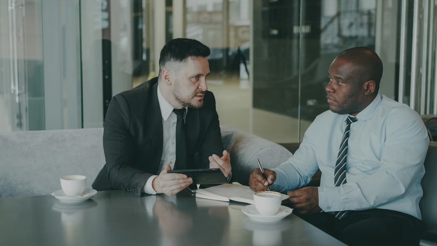 Two businessmen in discussion over coffee